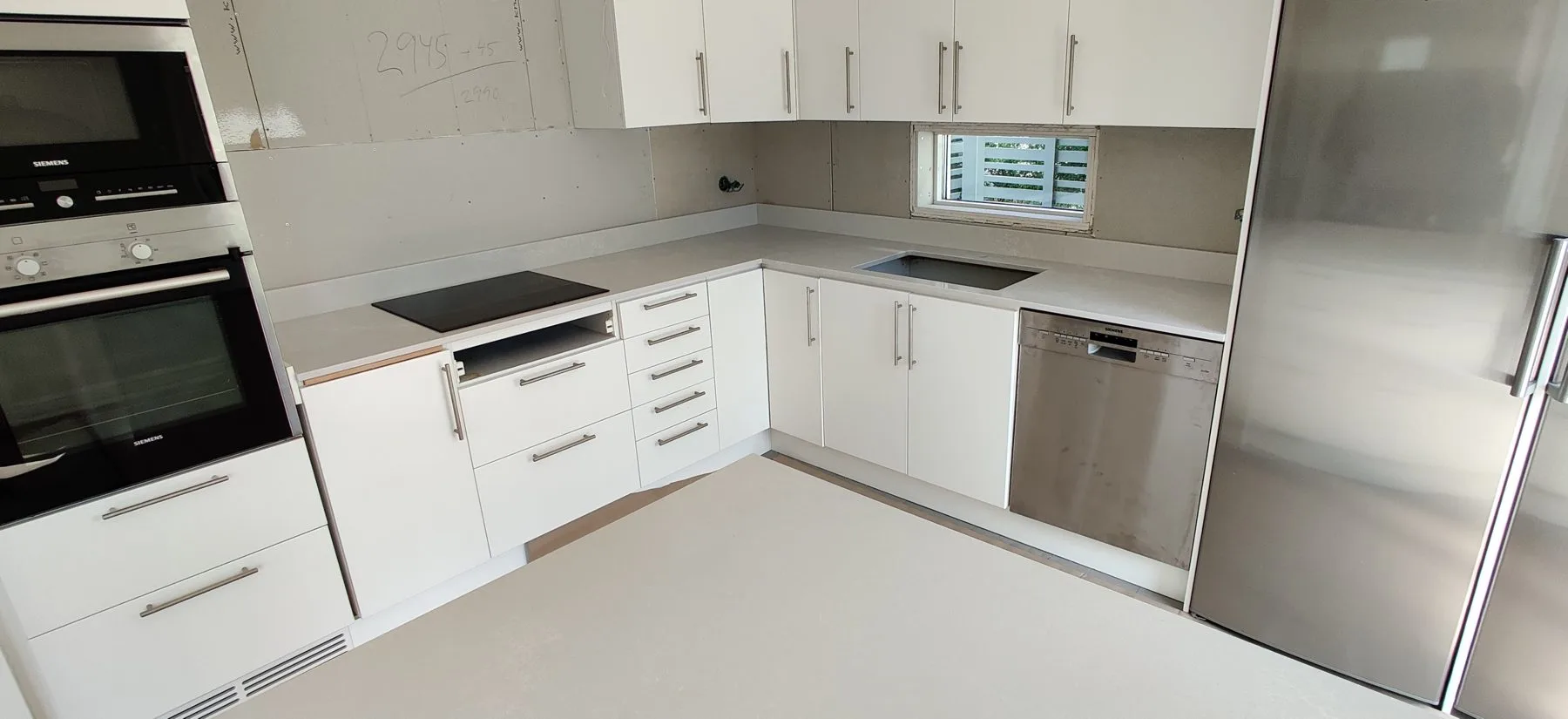 Caesarstone Alpine Mist quartz worktop in a white kitchen, installed by Stoneks
