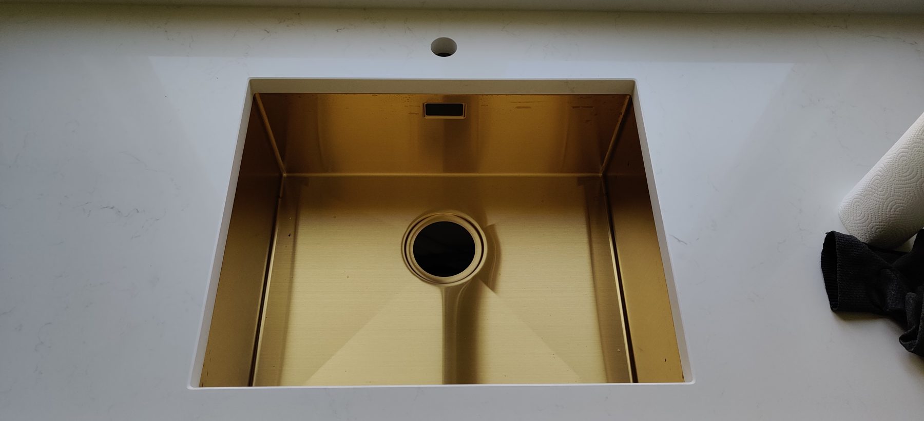 Caesarstone Frosty Carrina bordplade med vask i guld, monteret af Stoneks