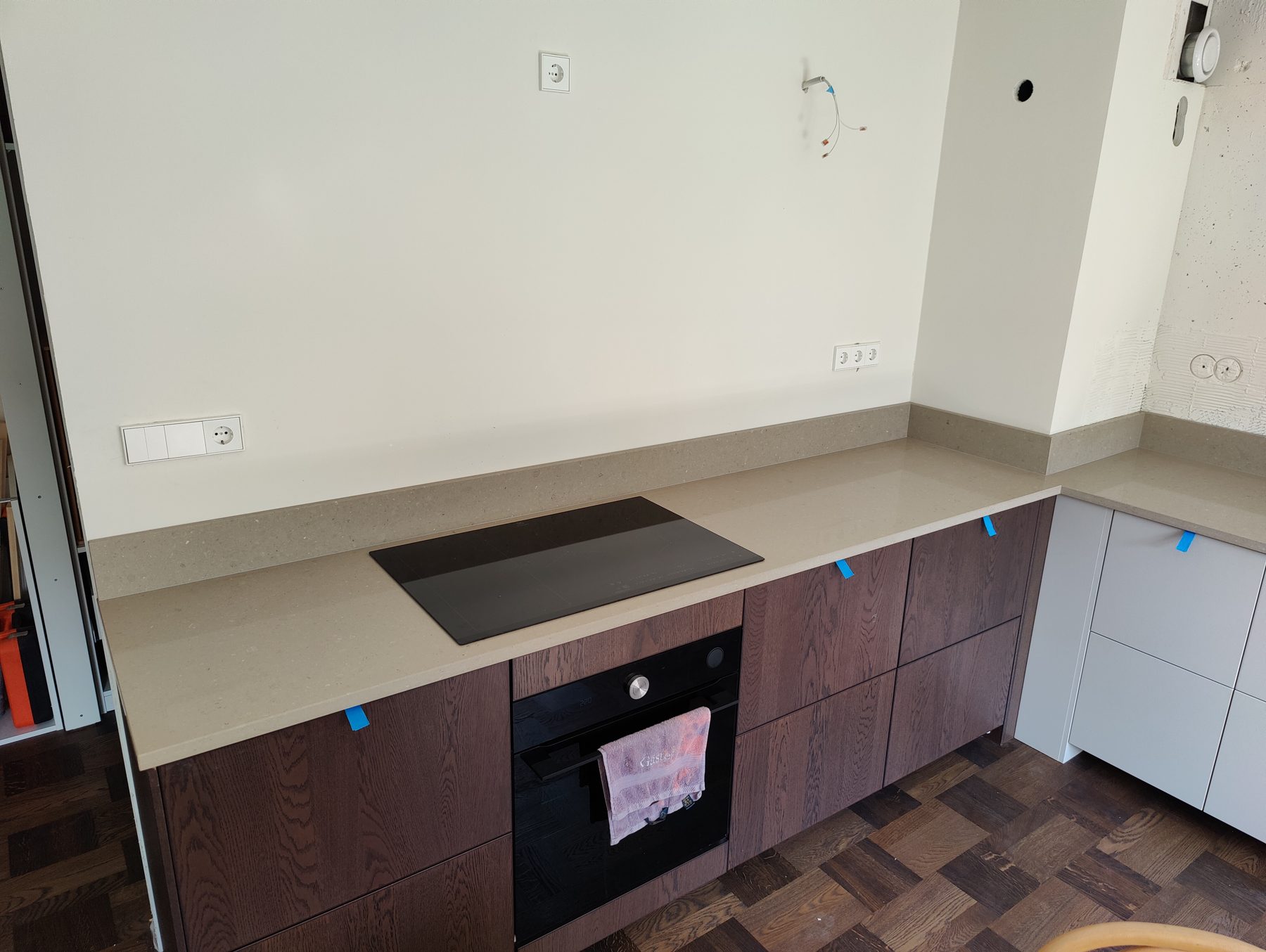 Caesarstone Shitake bordplade i kvarts med mørke køkkenskabe, monteret af Stoneks